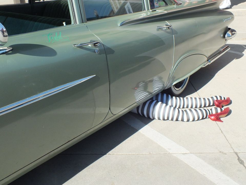 Photo of Witch legs sticking out from under a car with ruby slippers